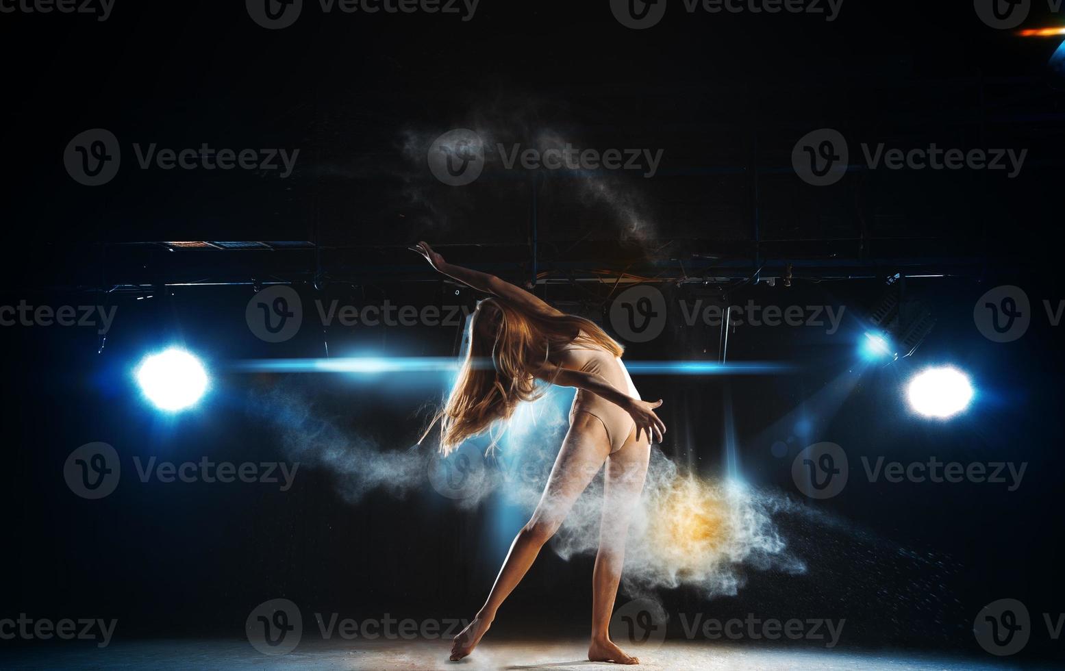 Sexy ballerina on stage posing against the backdrop of the spotlight photo