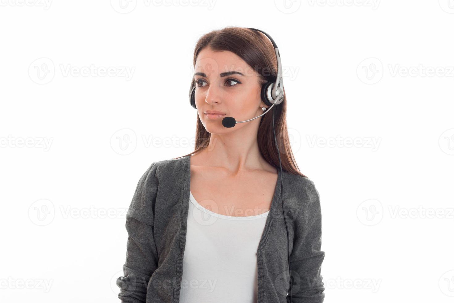 cute young girl stands in the headphones with a microphone and looks toward photo