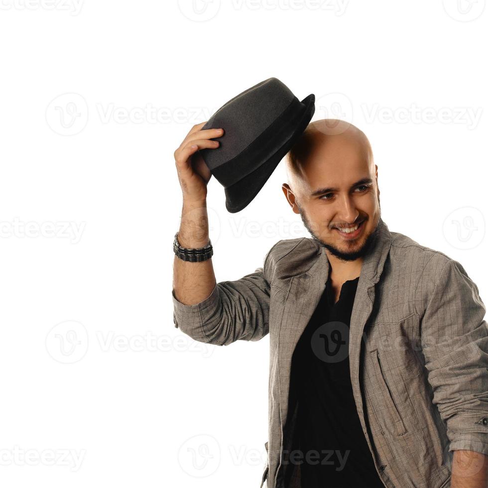 joven glamuroso con sombrero y chaqueta mirando hacia otro lado y sonriendo foto