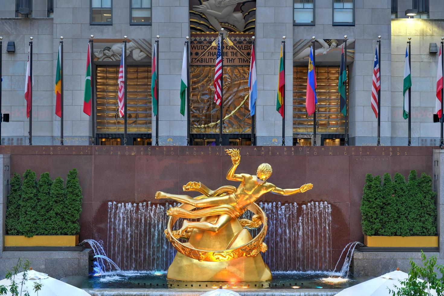 New York, NY, USA - Jul 2, 2020 -  Real estate firm Tishman Speyer fitted masks on Prometheus and other classic statues in Rockefeller Center to remind New Yorkers to wear COVID-19 face coverings. photo