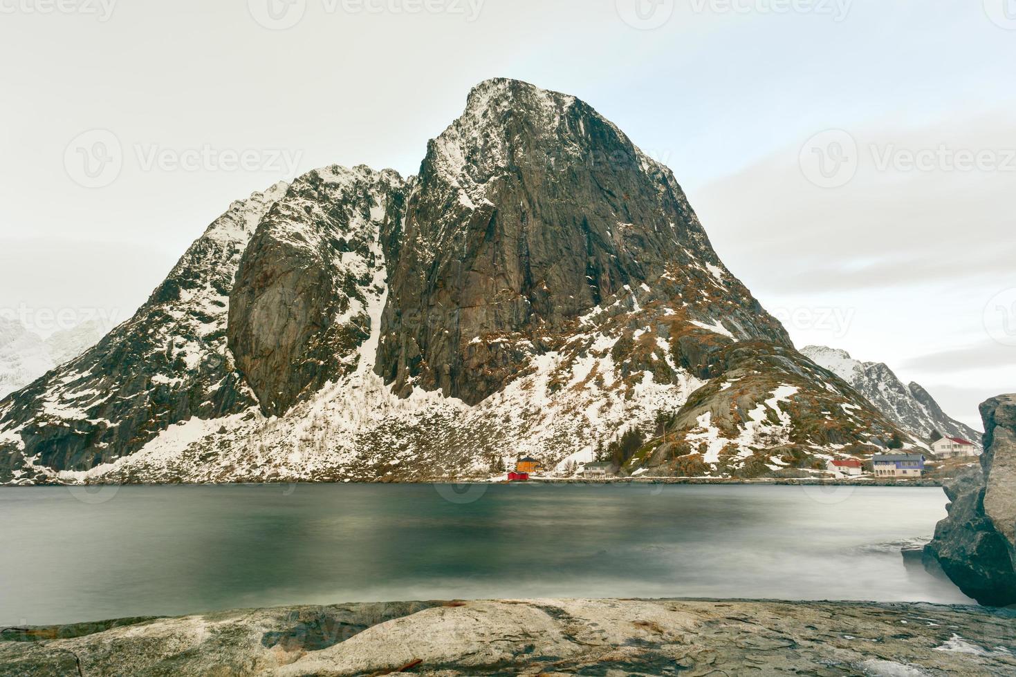 cabaña de pesca en el pico de la montaña hamnoy y lilandstinden en invierno en reine, islas lofoten, noruega. foto