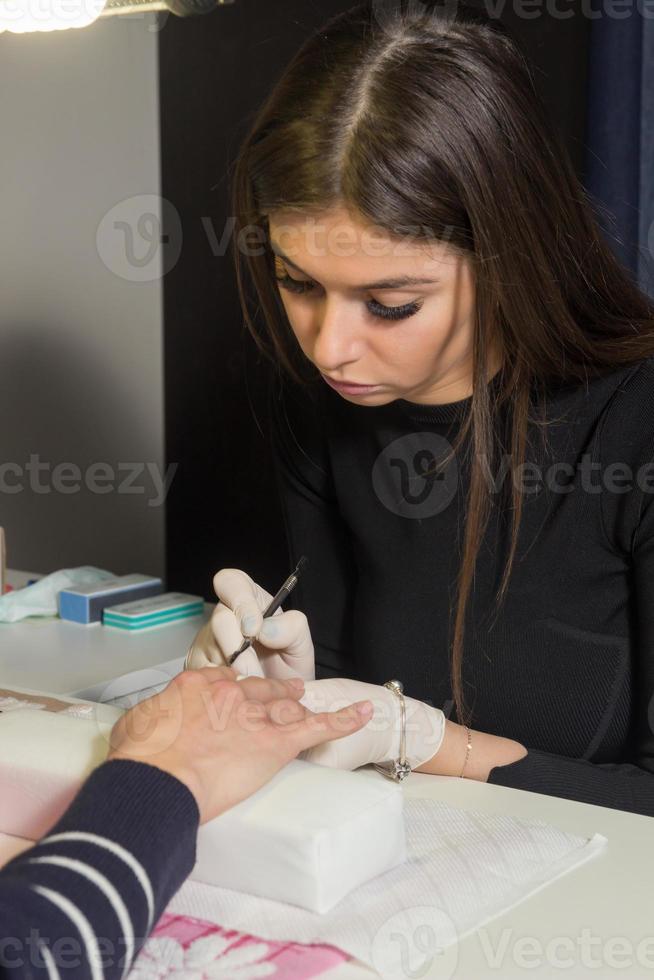 Manicurist is making manicure photo