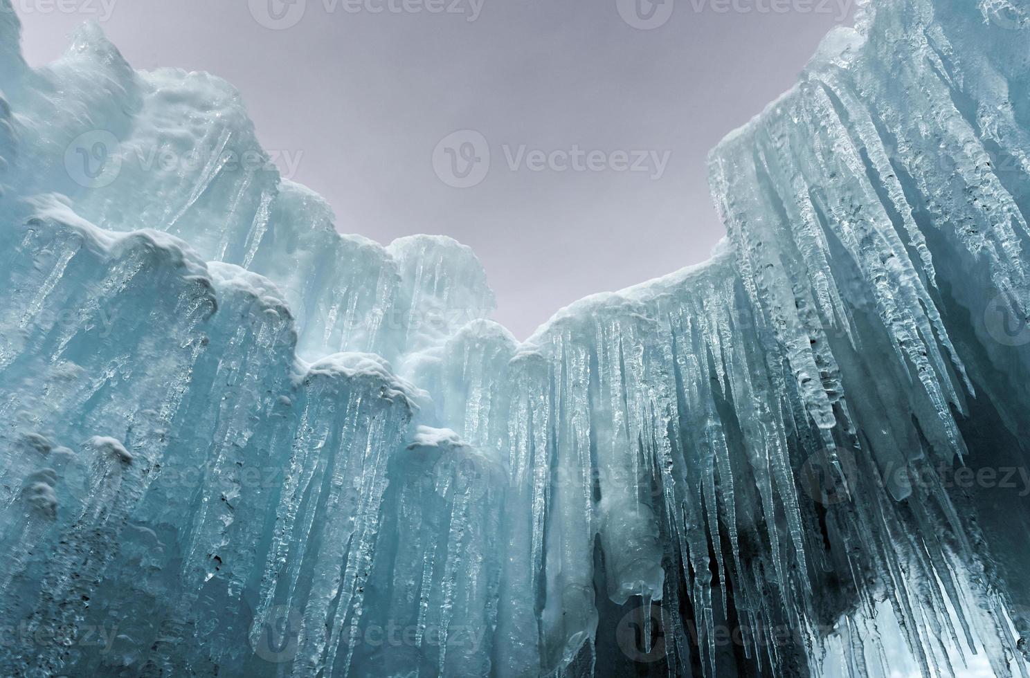 Translucent blue icicles in a frozen ice wall. photo