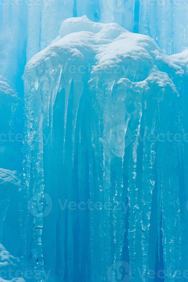 Translucent blue icicles in a frozen ice wall. photo