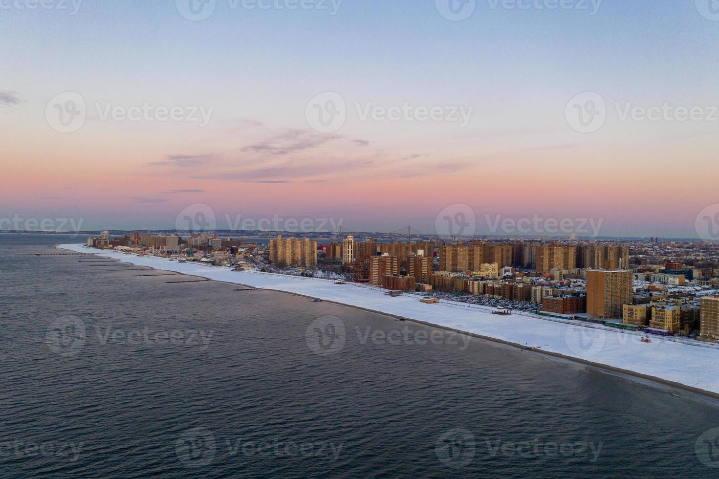 vista aérea de una playa de Coney Island cubierta de nieve durante el invierno al amanecer en Brooklyn, Nueva York foto