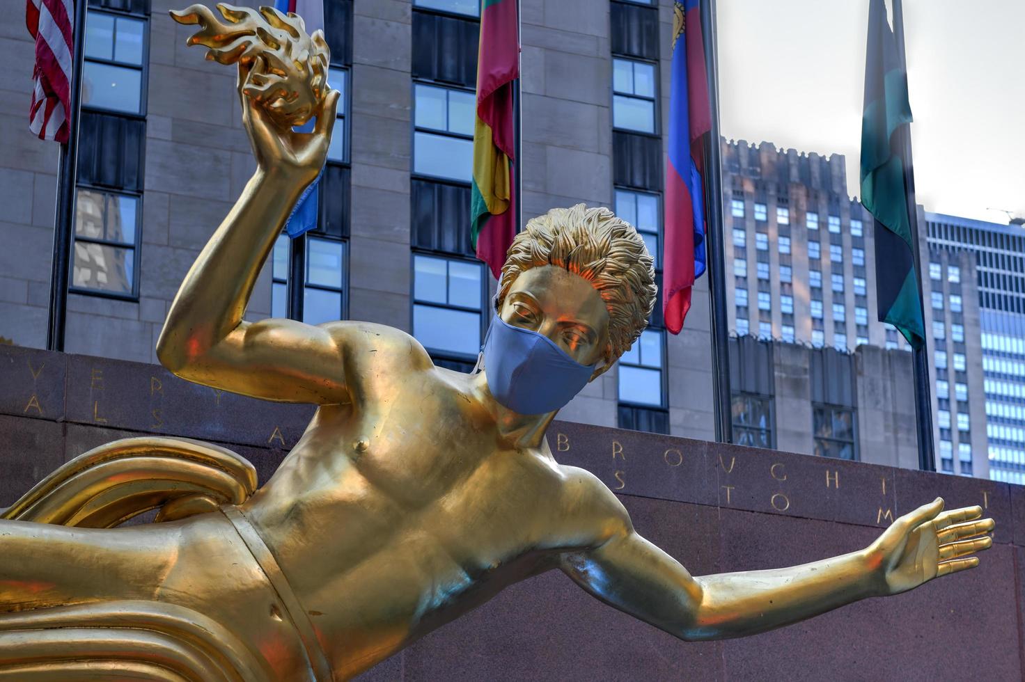 New York, NY, USA - Jul 2, 2020 -  Real estate firm Tishman Speyer fitted masks on Prometheus and other classic statues in Rockefeller Center to remind New Yorkers to wear COVID-19 face coverings. photo