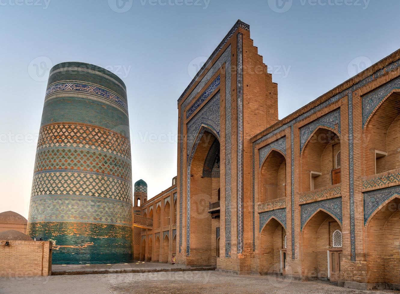 Kalta Minor Minaret and the historic architecture of Itchan Kala, walled inner town of the city of Khiva, Uzbekistan a UNESCO World Heritage Site. photo