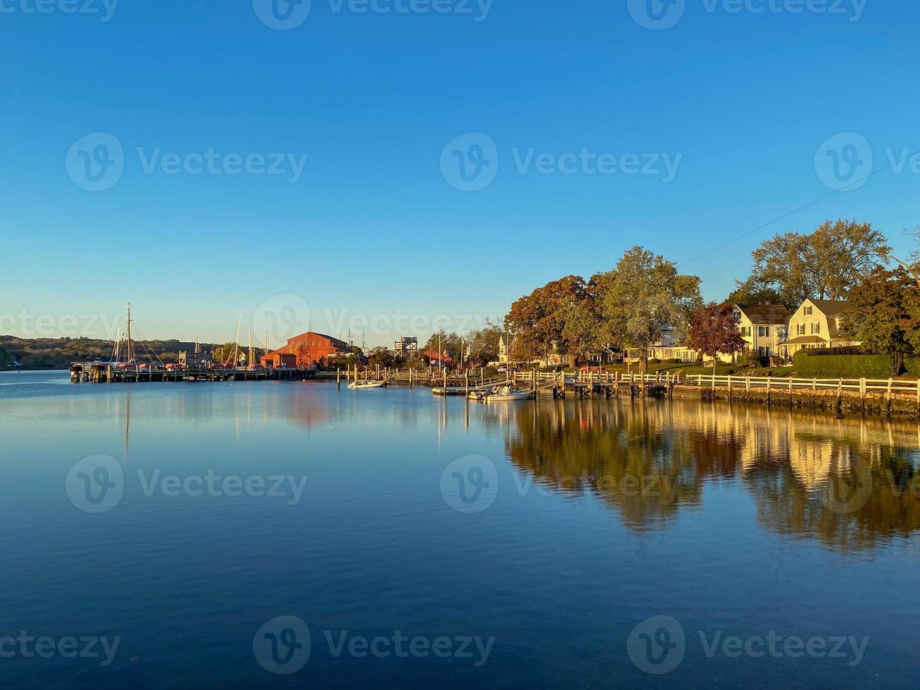 Sunset along the Mystic River in Mystic, Connecticut as reflections float above the still water. photo