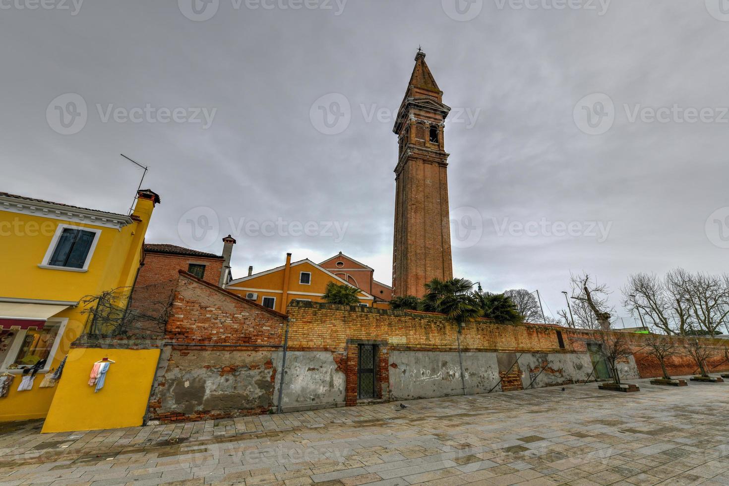 el campanario inclinado de la iglesia de san martino en la isla de burano es una iglesia católica romana del siglo XVI en venecia, italia. foto