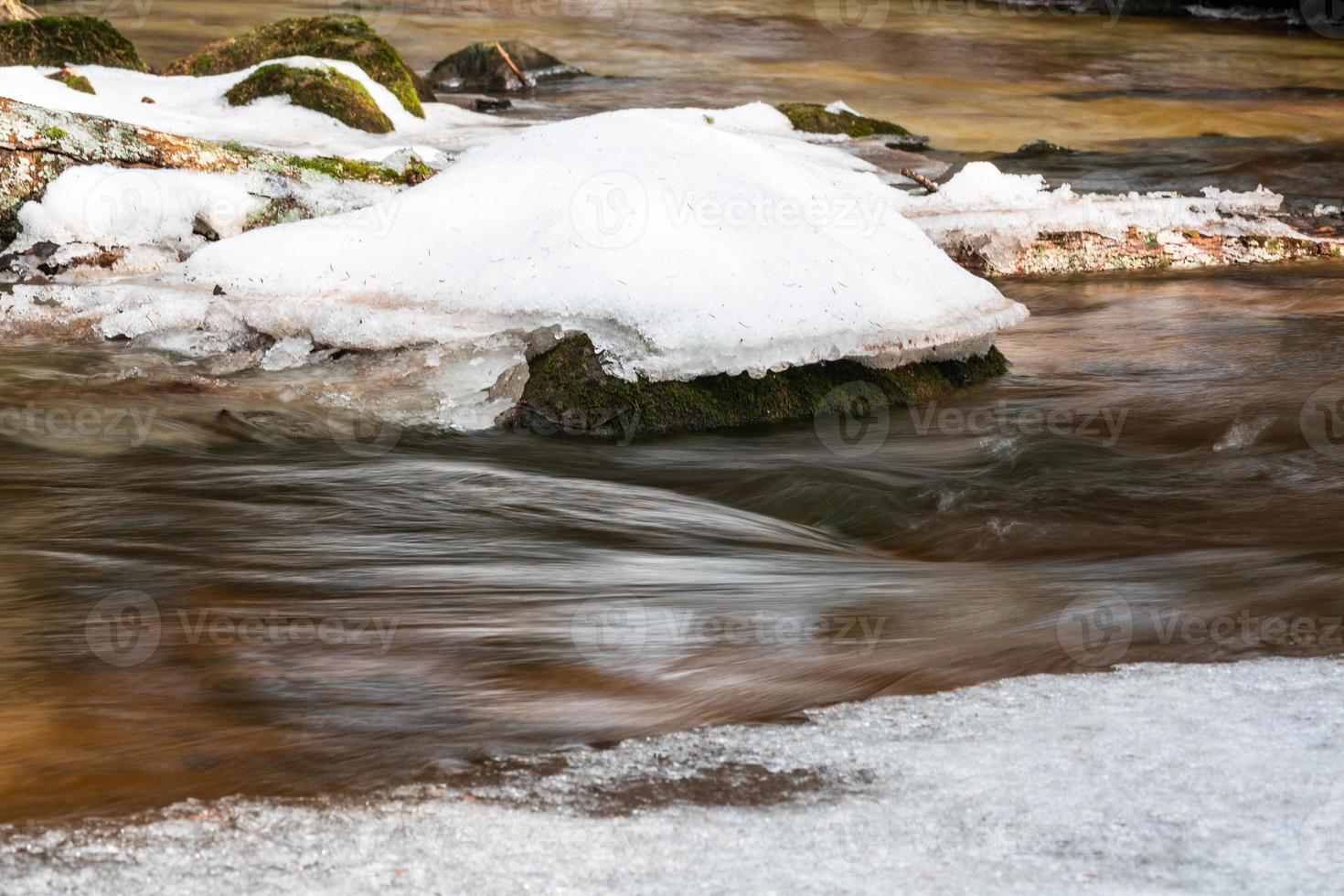 un pequeño río de bosque rocoso en invierno foto