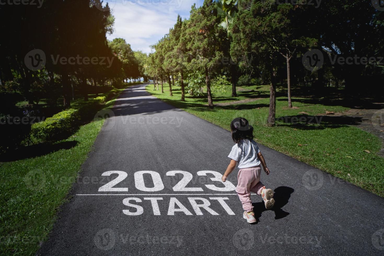 Asian baby running start into the new year 2023. Start up of runner woman running on nature race track go to Goal of Success. People running as part of Number 2023. Sport health care. photo