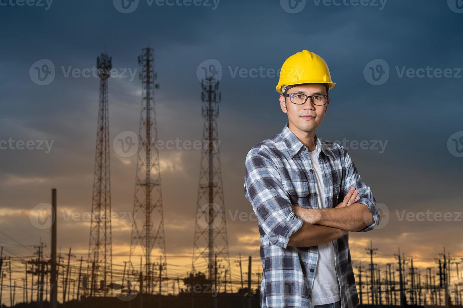 ingeniero asiático hombre empresario industria de la construcción. ingeniero masculino cruzó los brazos trabajando en poste eléctrico, fabricación de plantas de energía. la construcción de ingeniería civil usa un casco de seguridad amarillo foto