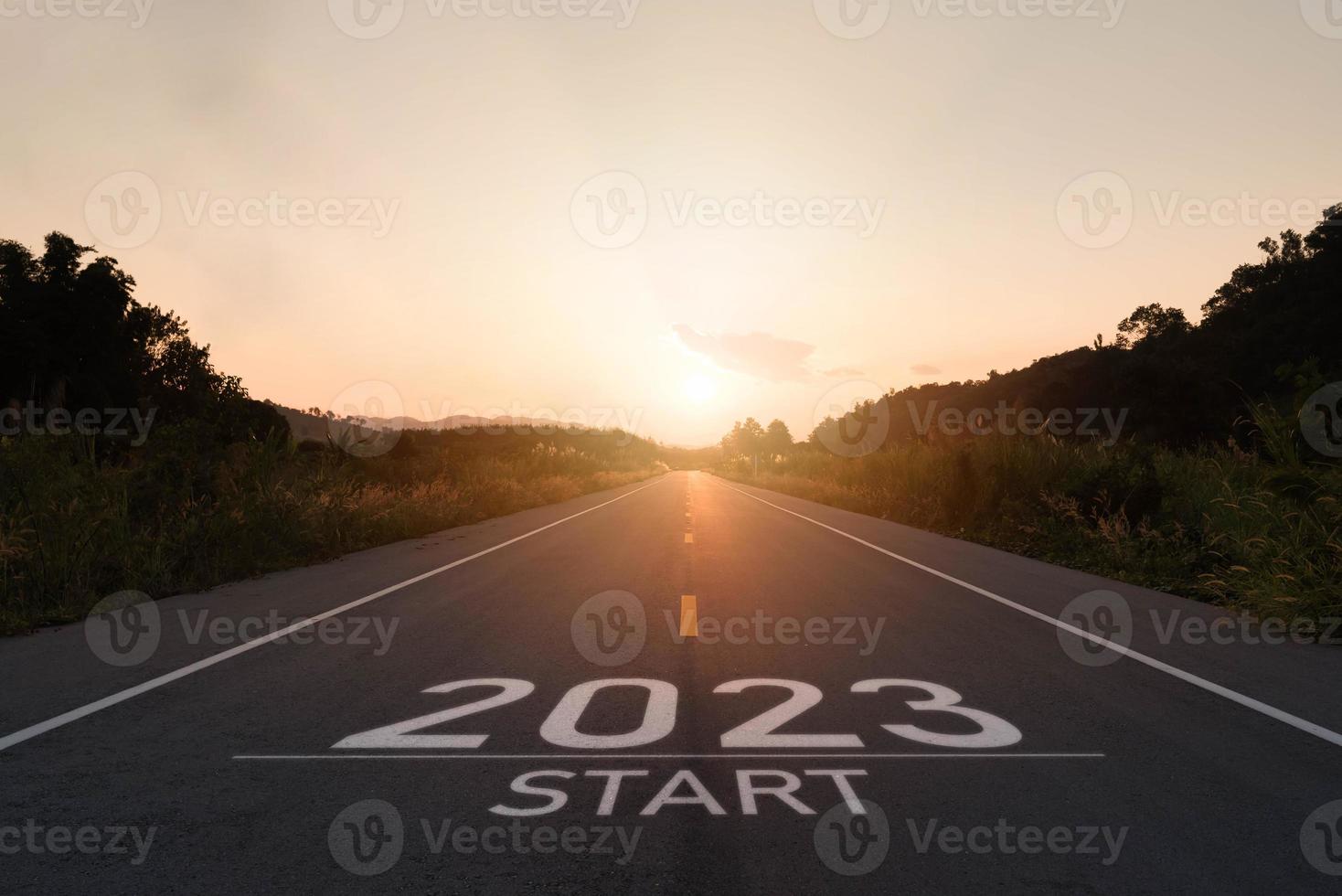 Happy new year 2023,2023 symbolizes the start of the new year. The letter start new year 2023 on the road in the nature route roadway sunset have tree environment ecology or greenery wallpaper concept photo