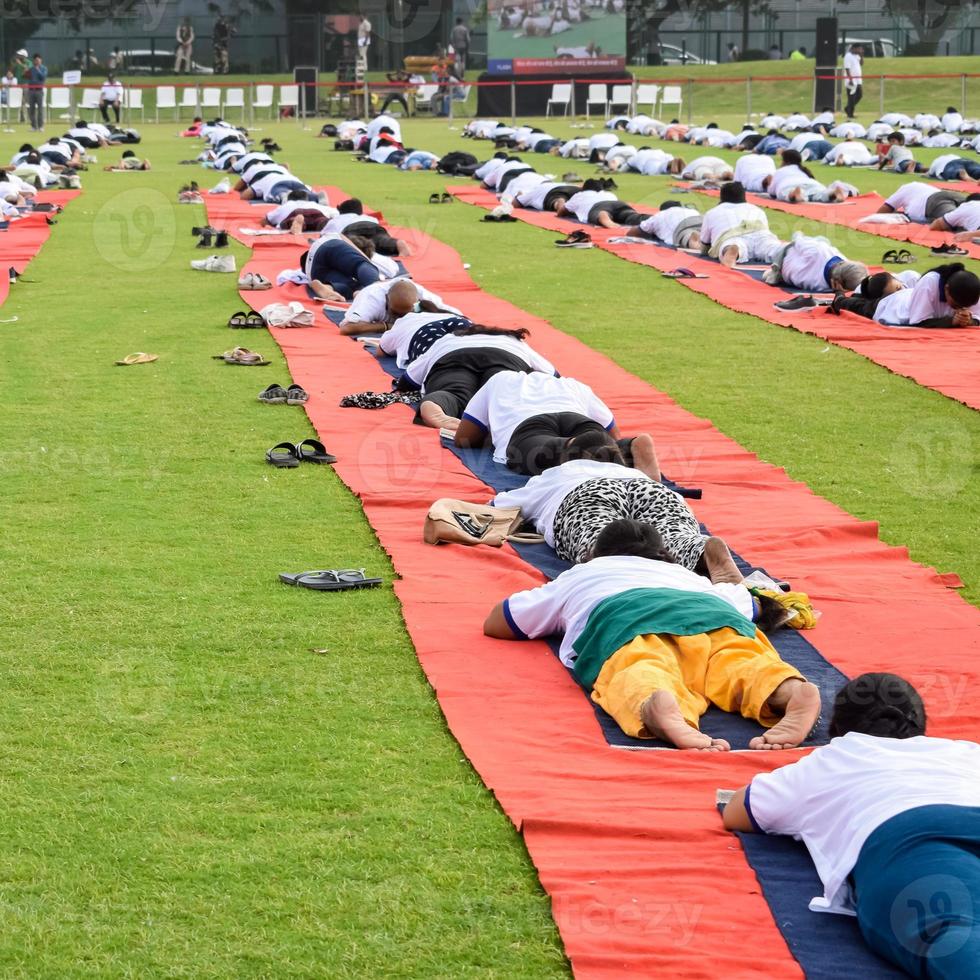 Group Yoga exercise session for people of different age groups at cricket stadium in Delhi on International Yoga Day, Big group of adults attending yoga session photo