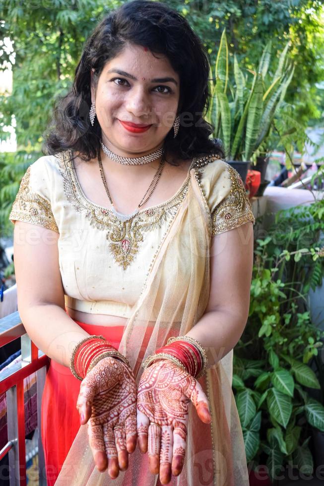 Beautiful woman dressed up as Indian tradition with henna mehndi design on her both hands to celebrate big festival of Karwa Chauth, Karwa Chauth celebrations by Indian woman for her husband photo