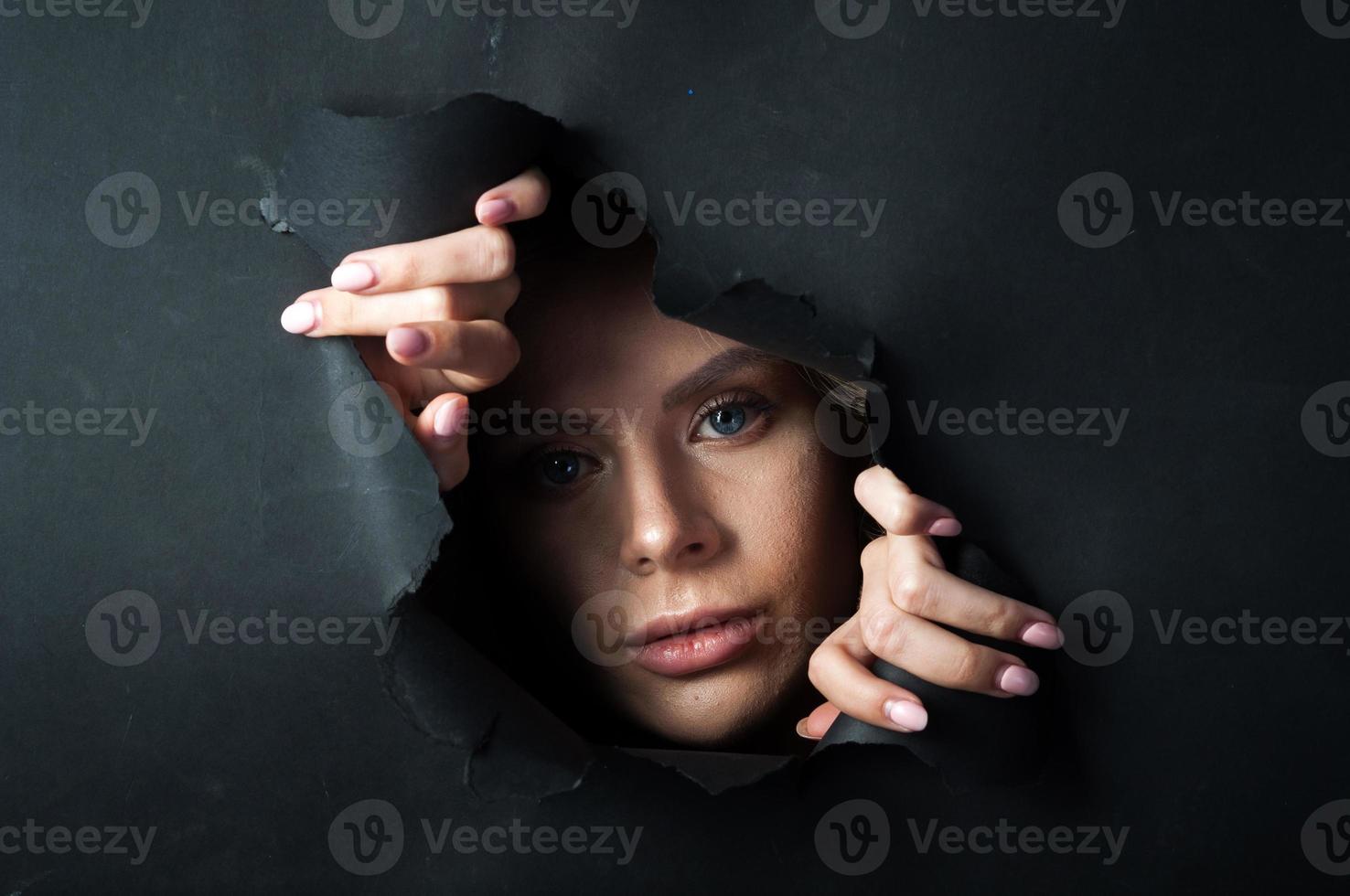 The girl's face appears on a black background. photo