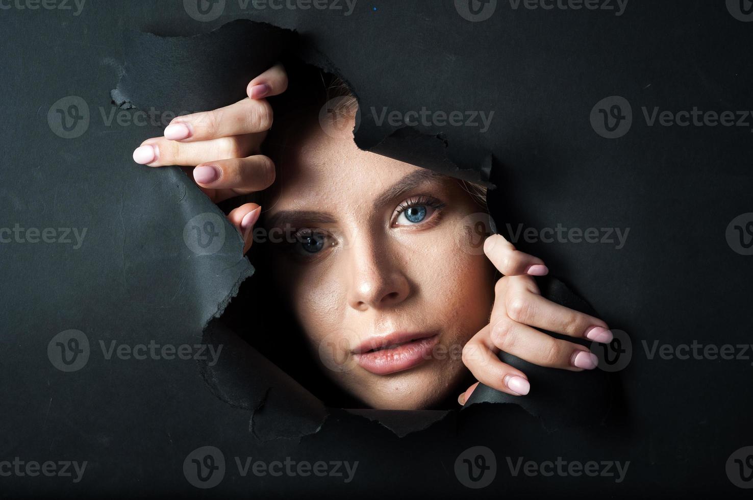 The girl's face appears on a black background. photo