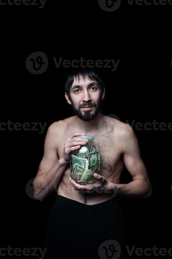 Young man with money bottle on black background photo