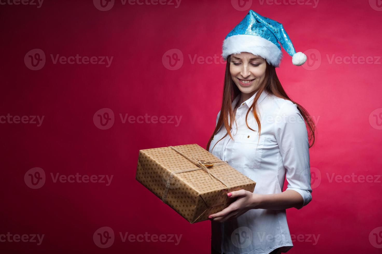 Girl posing in the Studio on a pink background, in a Christmas hat photo