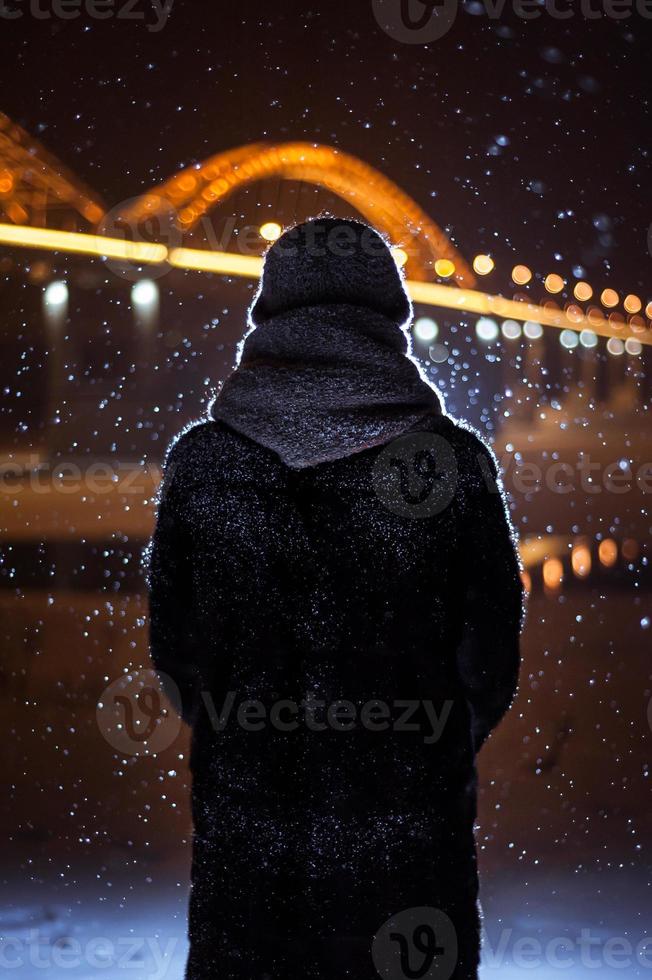 silhouette of a man on the background of falling snow in winter photo