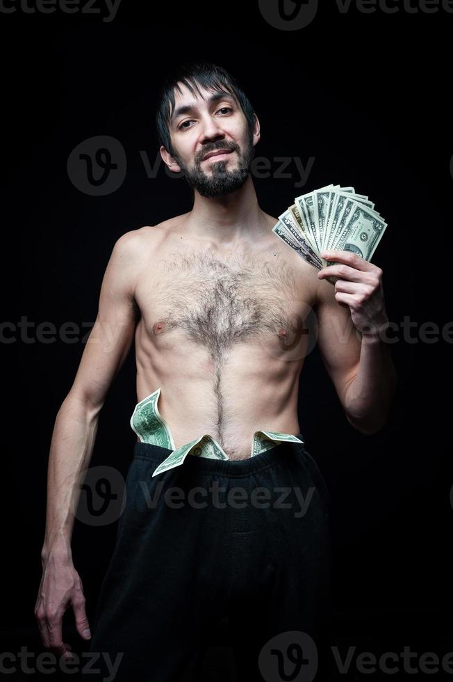 Young man with banknotes on black background photo