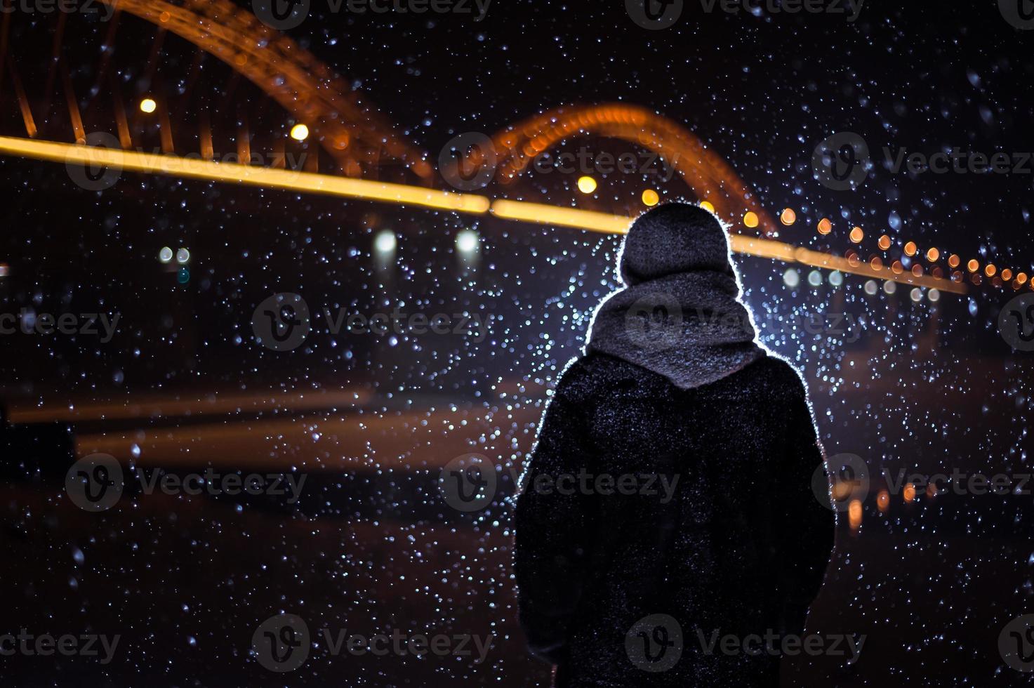 silhouette of a man on the background of falling snow in winter photo
