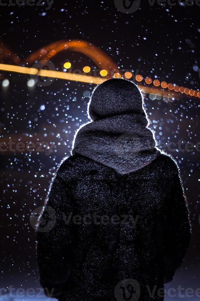 silhouette of a man on the background of falling snow in winter photo