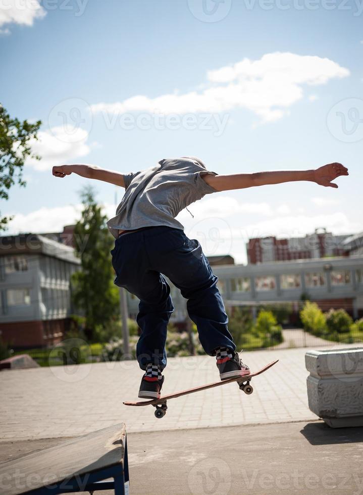 skateboarder does the trick with a jump on the ramp. Skateboarder flying in the air photo