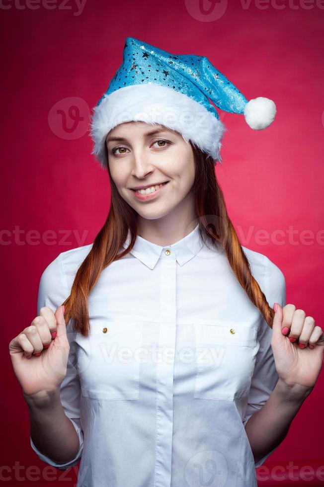 Girl posing in the Studio on a pink background, in a Christmas hat photo