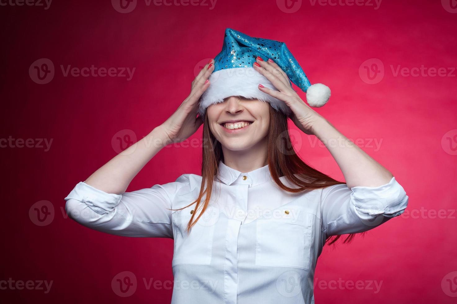 Girl posing in the Studio on a pink background, in a Christmas hat photo