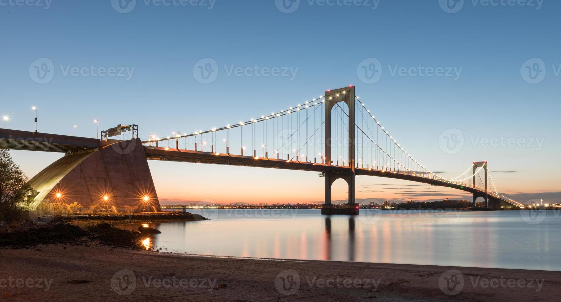 The Bronx-Whitestone Bridge reflecting on the East River at night in New York. photo