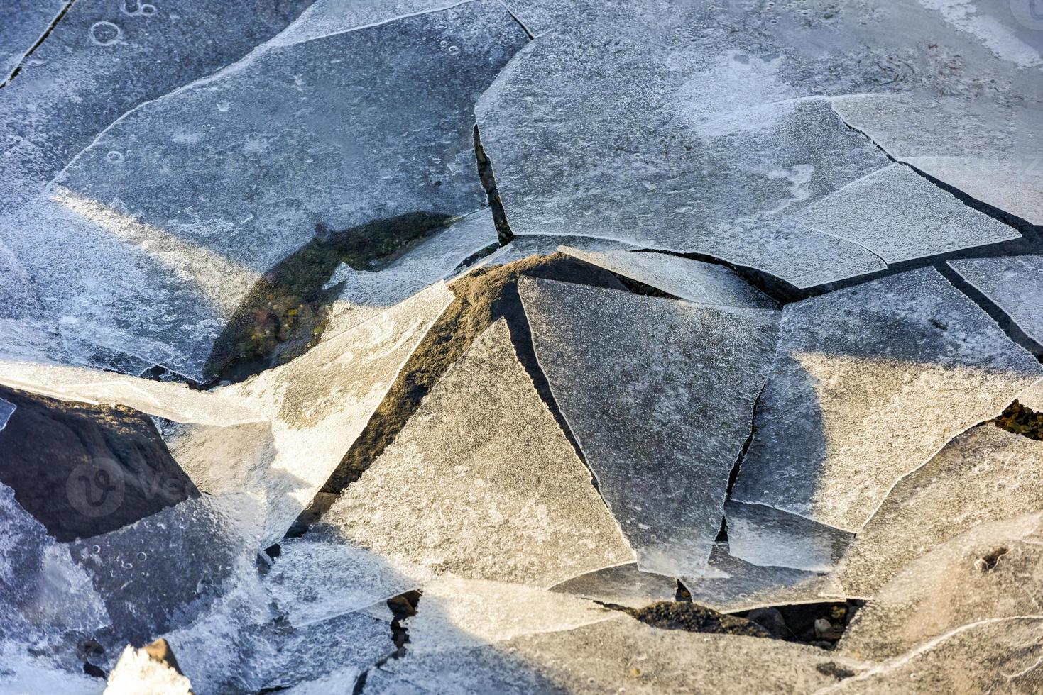 Rock cracking through the ice in Boosen in the Lofoten Islands, Norway in the winter. photo
