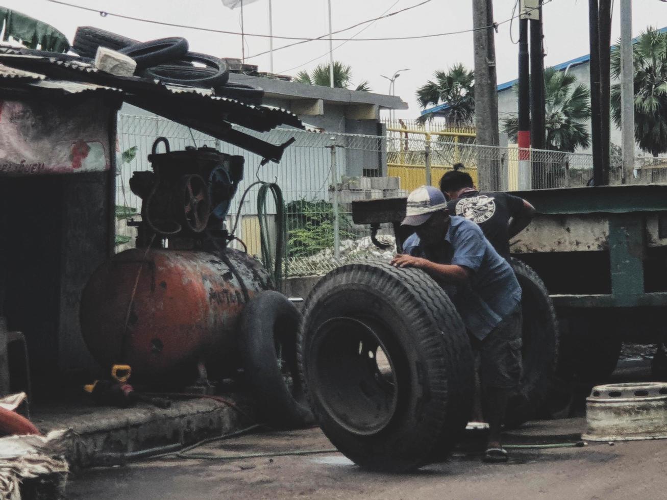 yakarta, indonesia en julio de 2022. dos hombres estaban reemplazando un neumático de camión reventado. foto