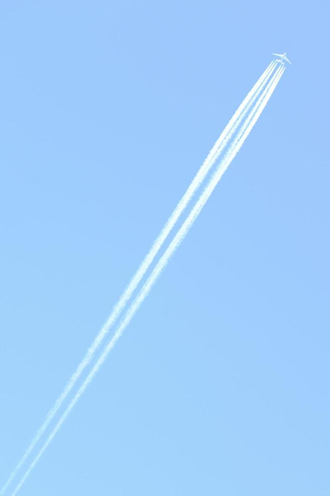 Traces and white streaks from the jet engines in the plane, white stripes in the sky. photo