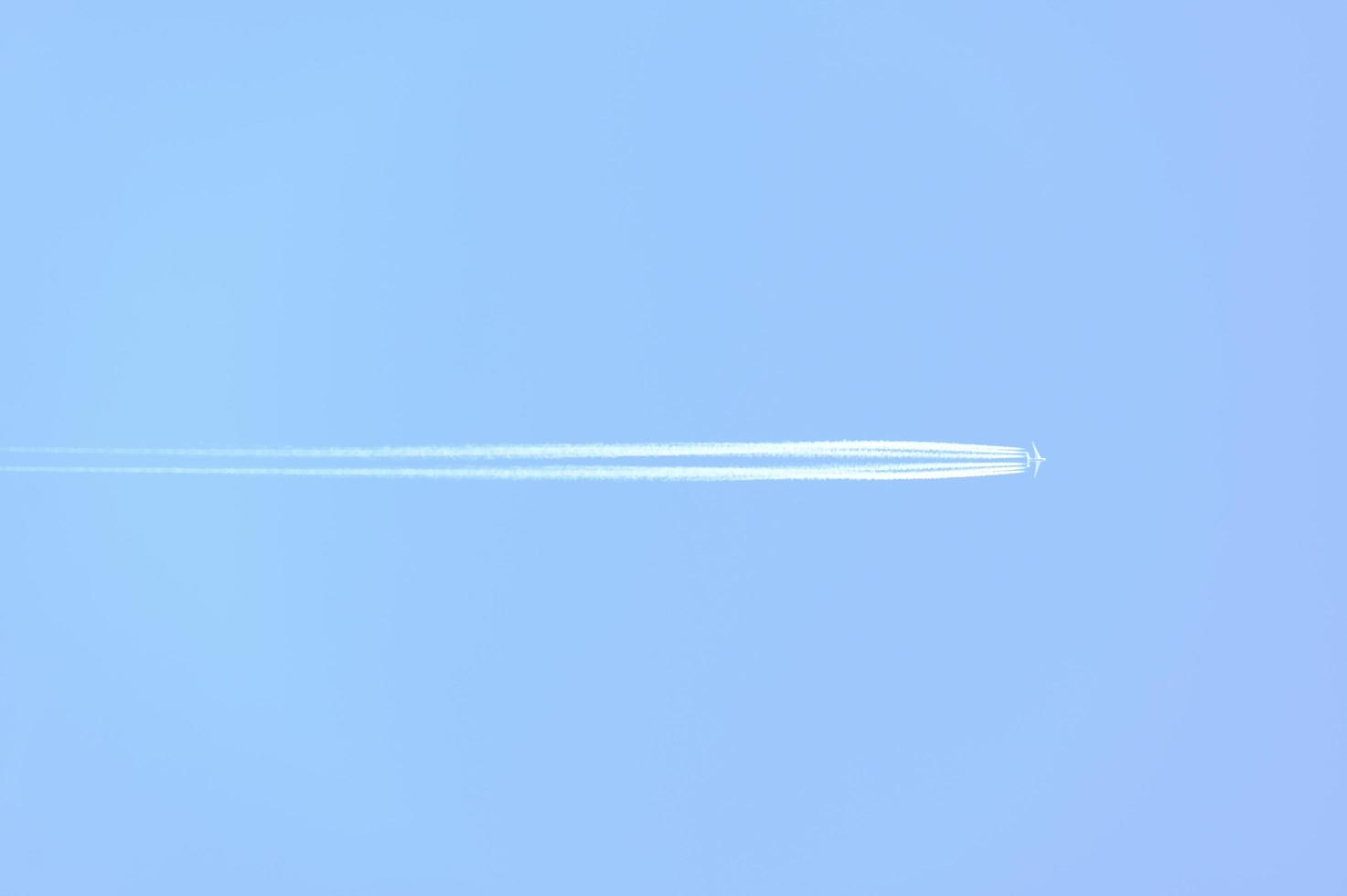 Traces and white streaks from the jet engines in the plane, white stripes in the sky. photo