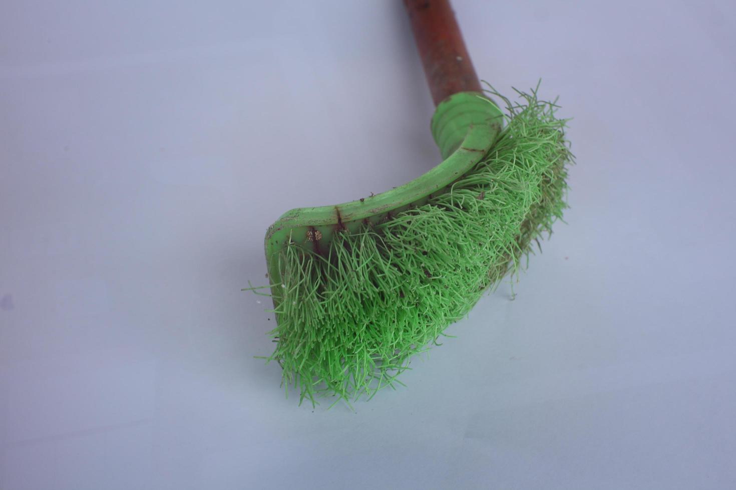 used green toilet brush isolated on white background photo