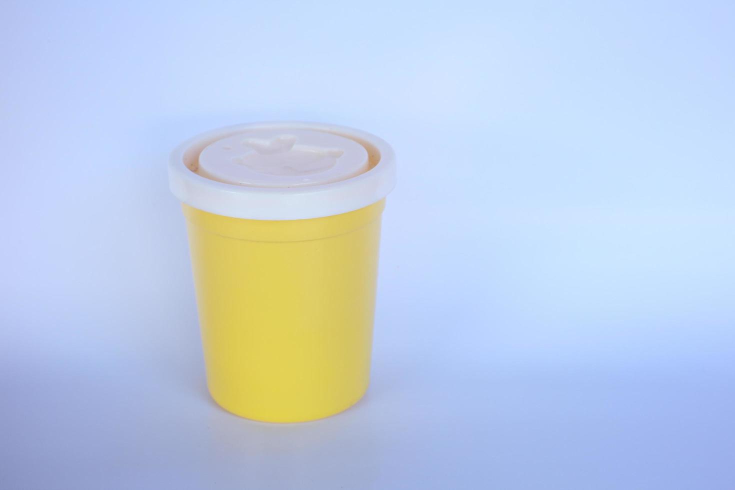 pequeña botella amarilla sobre un fondo completamente blanco foto