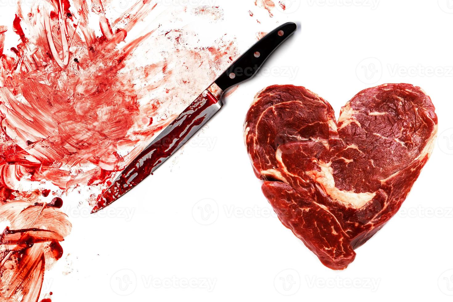 Fresh raw meat in shape of heart, knife and blood splatters photo