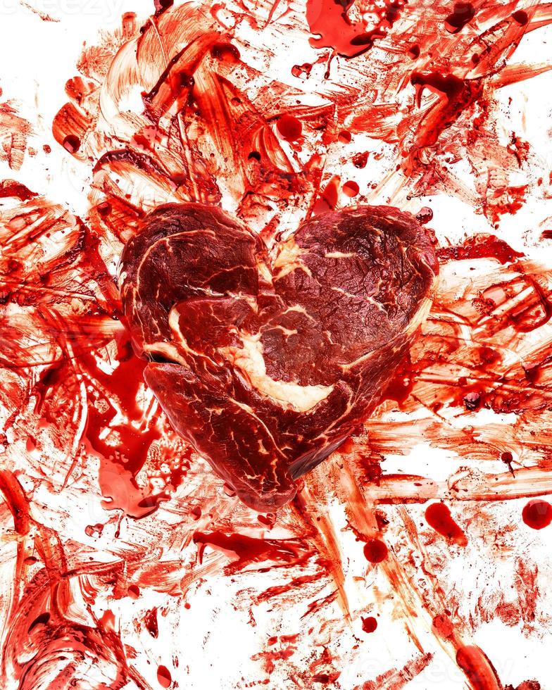 Fresh raw meat in shape of heart and blood splatters photo