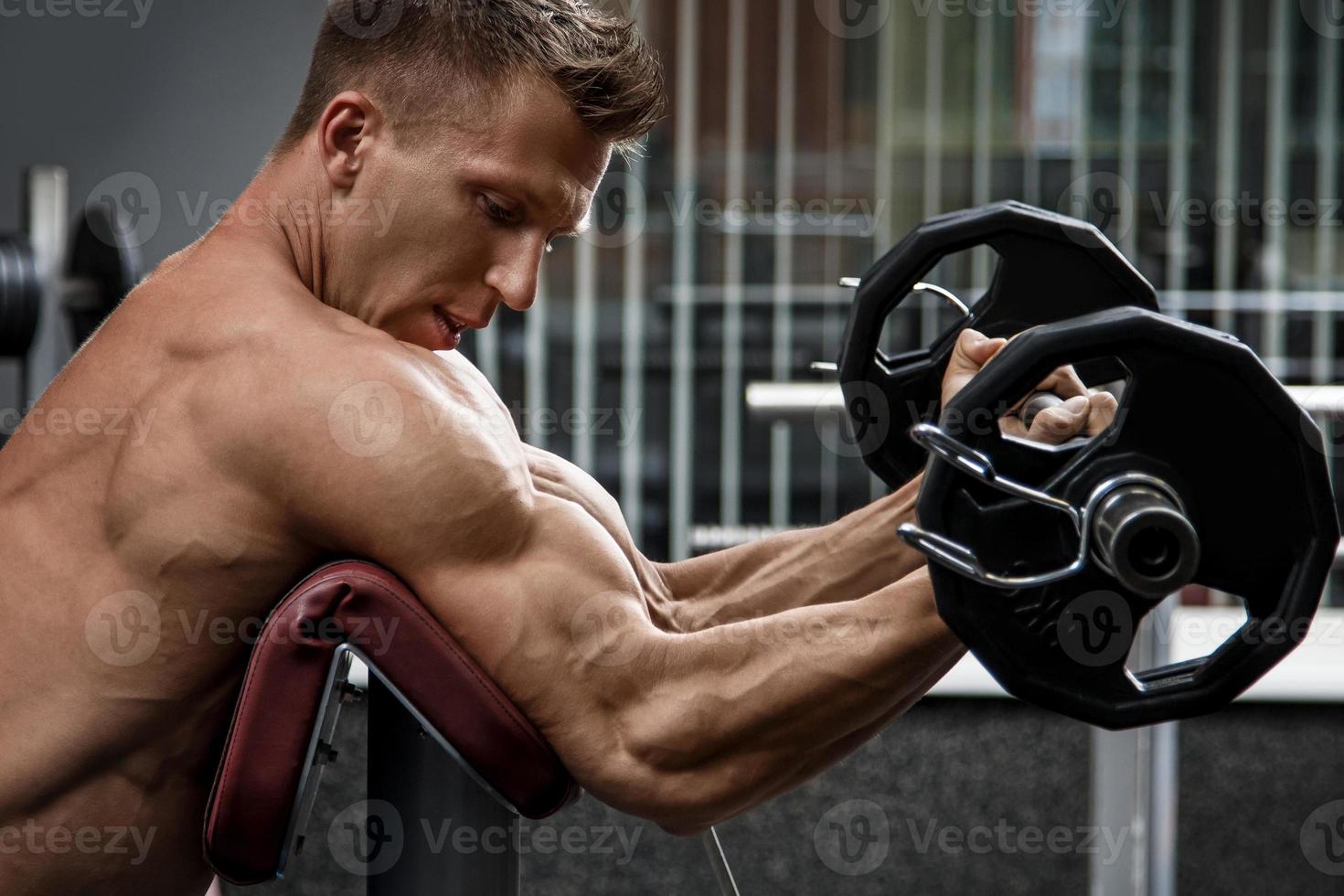 Muscular man during workout in the gym photo