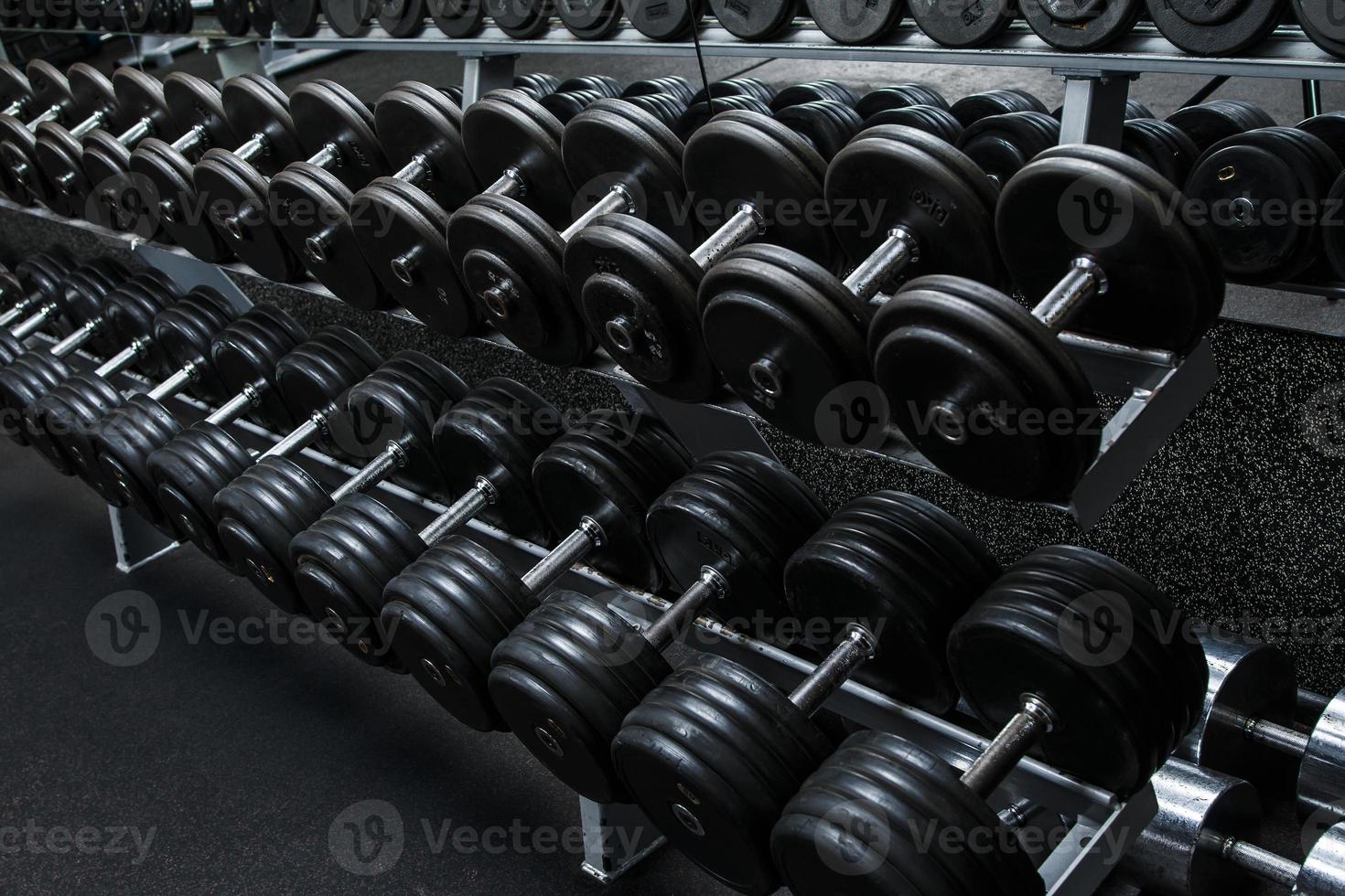 diferentes mancuernas negras en el gimnasio moderno foto