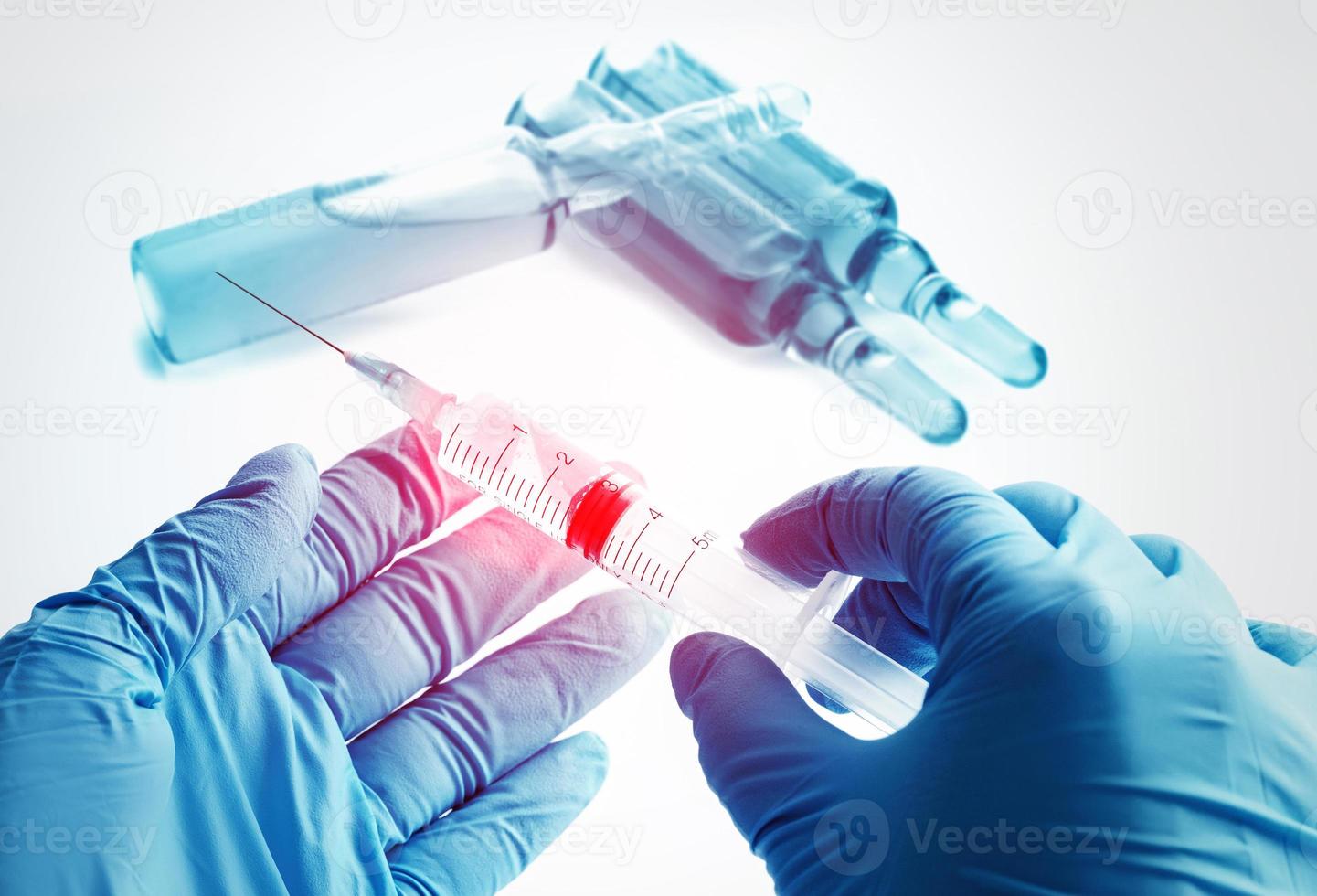 manos del médico sosteniendo una jeringa con una vacuna, remedio médico o cosméticos foto