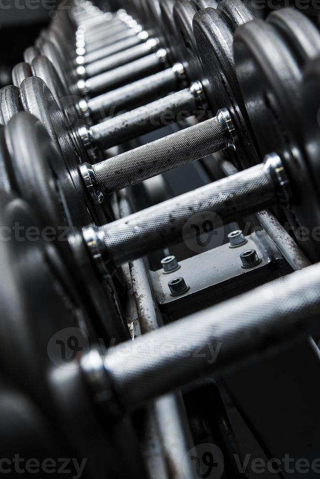 Different black dumbbells in the modern gym photo