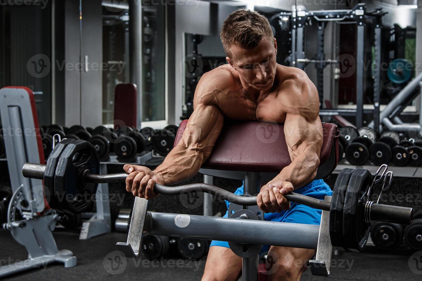 Muscular man during workout in the gym photo