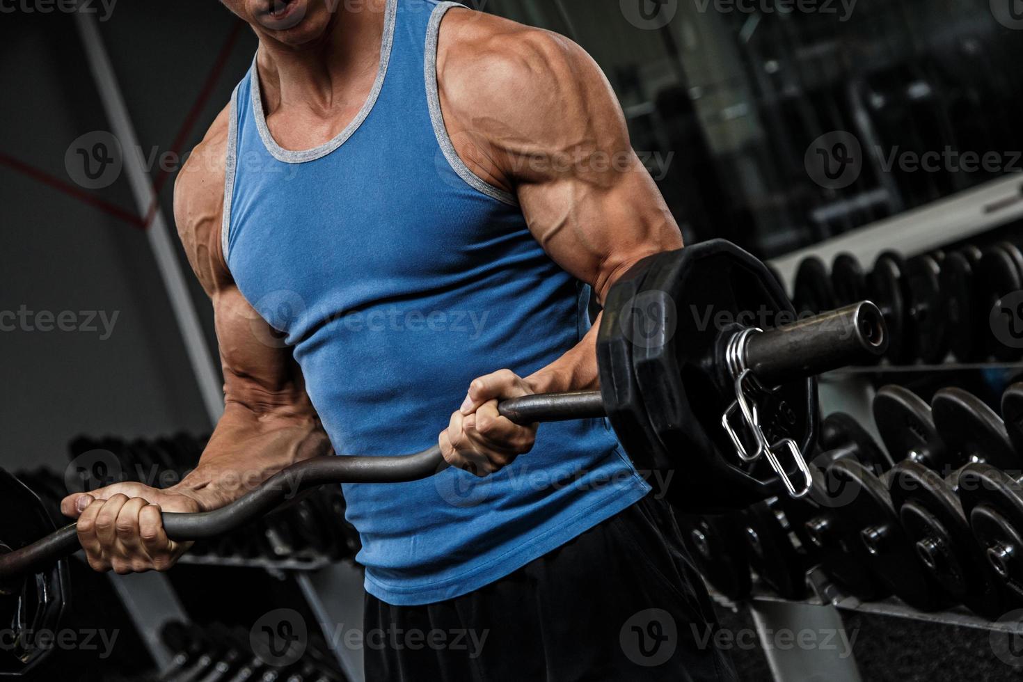 Muscular man during workout in the gym photo