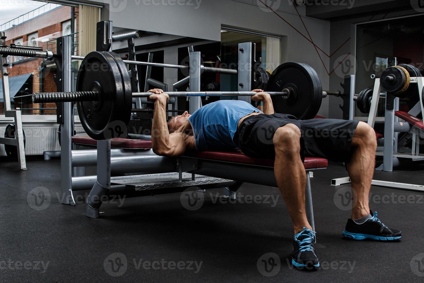 Muscular man during workout in the gym photo