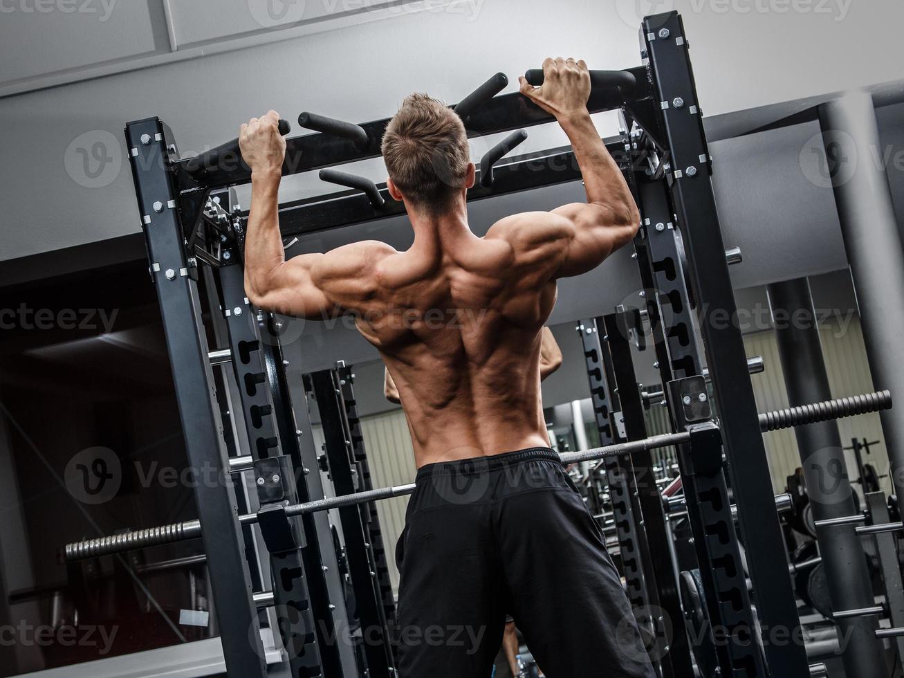 Muscular man during workout in the gym photo