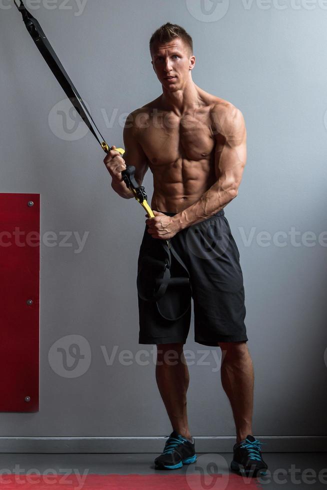 Muscular man during workout in the gym photo