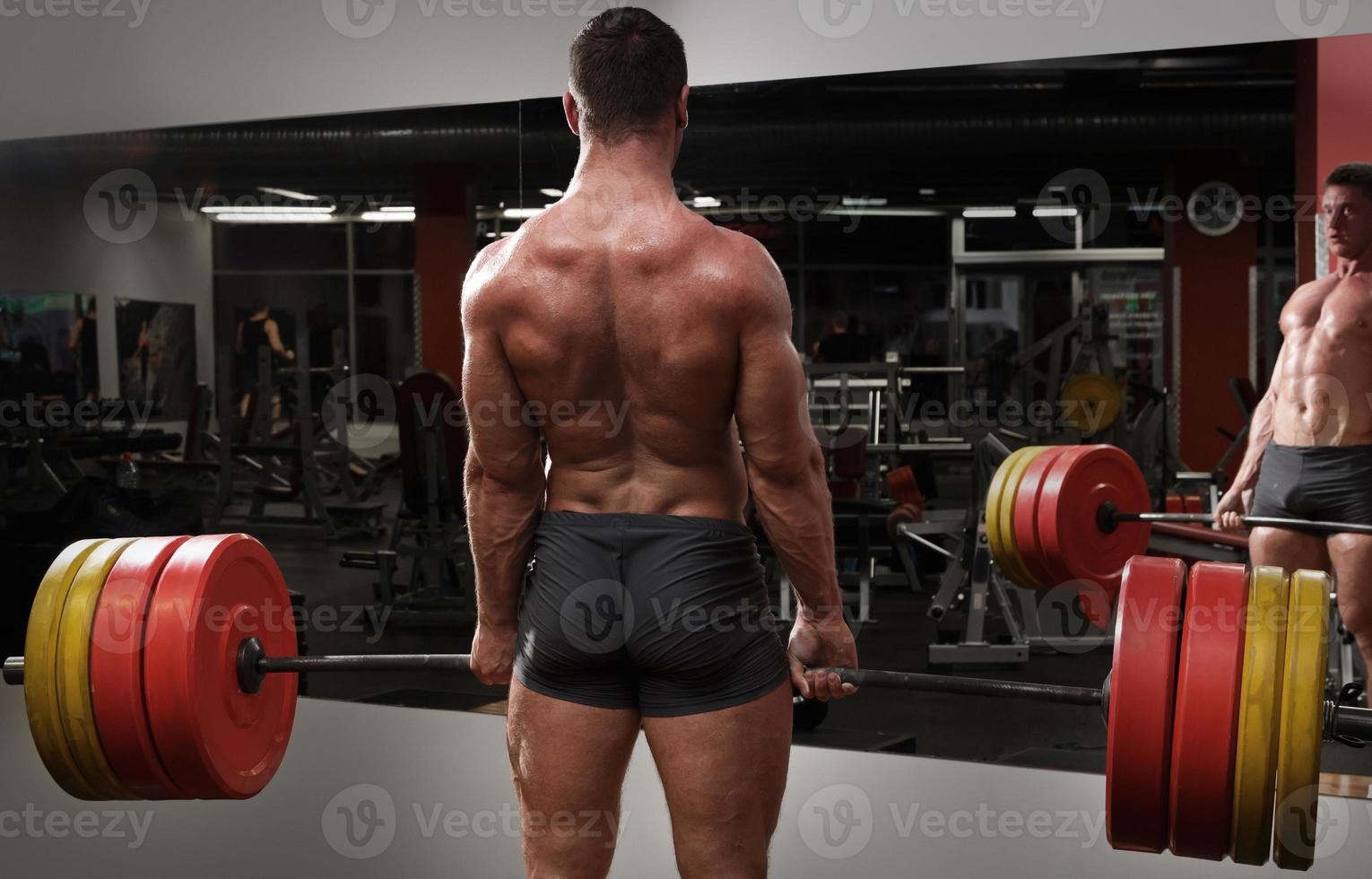 Strong man doing deadlift exercise in the gym photo