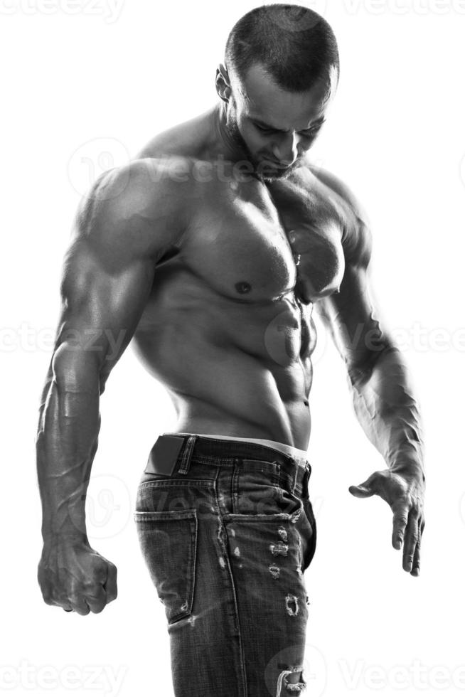 Handsome muscular man wearing jeans posing in studio photo